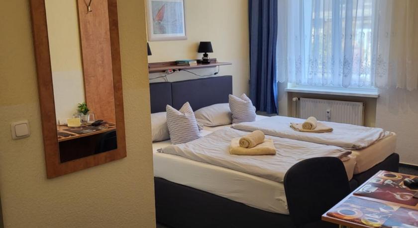 MonteurZimmer - Doppelzimmer mit Doppelbett und Schreibtisch mit Stühle und Spiegel  - Pension Hubertus 