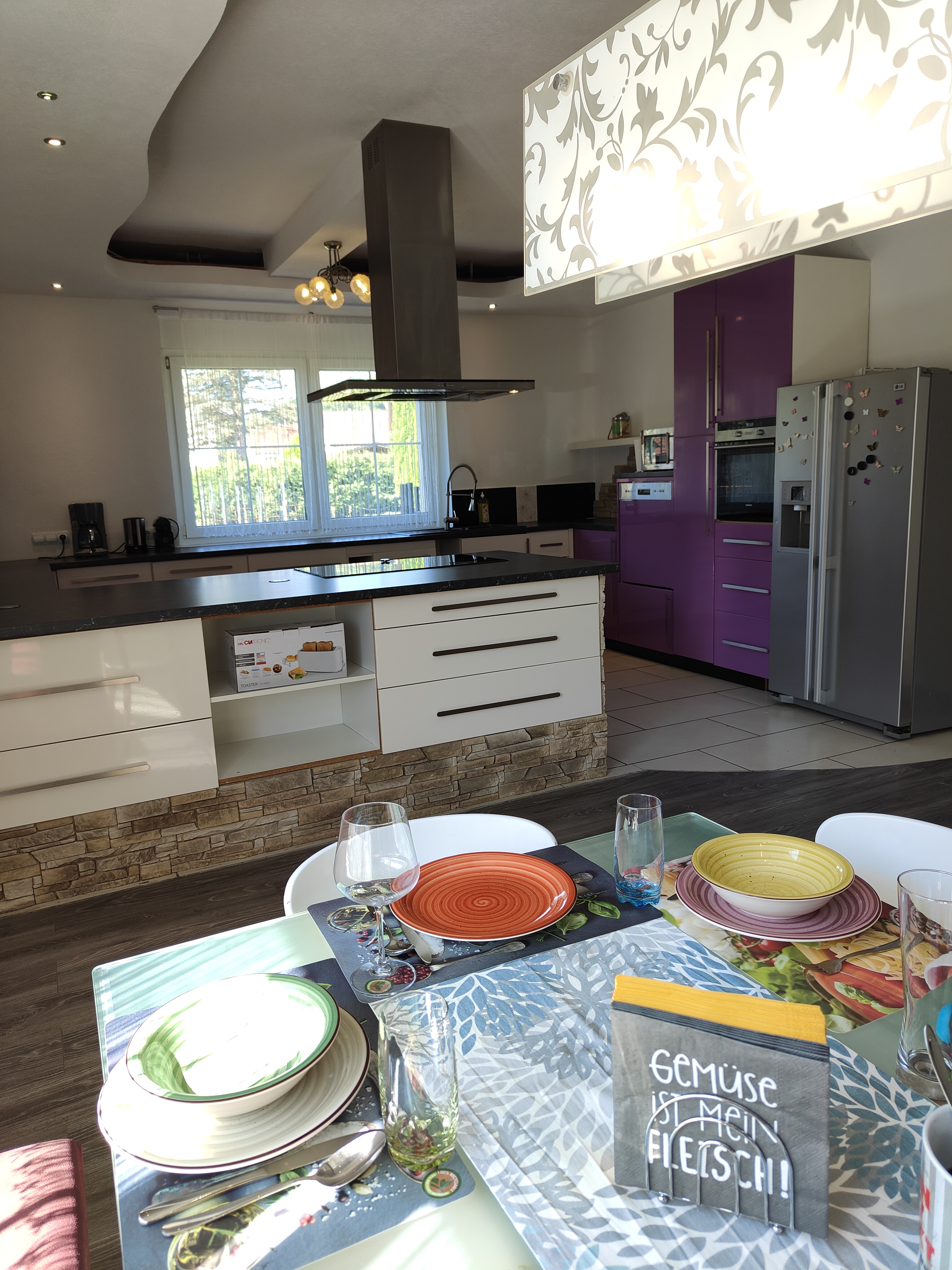 Monteur-Zimmer - Fernseher - Esstisch für bis zu 8 Personen mit Blick auf die vollausgestattete Küche.  - Ferienwohnung Dorfleben