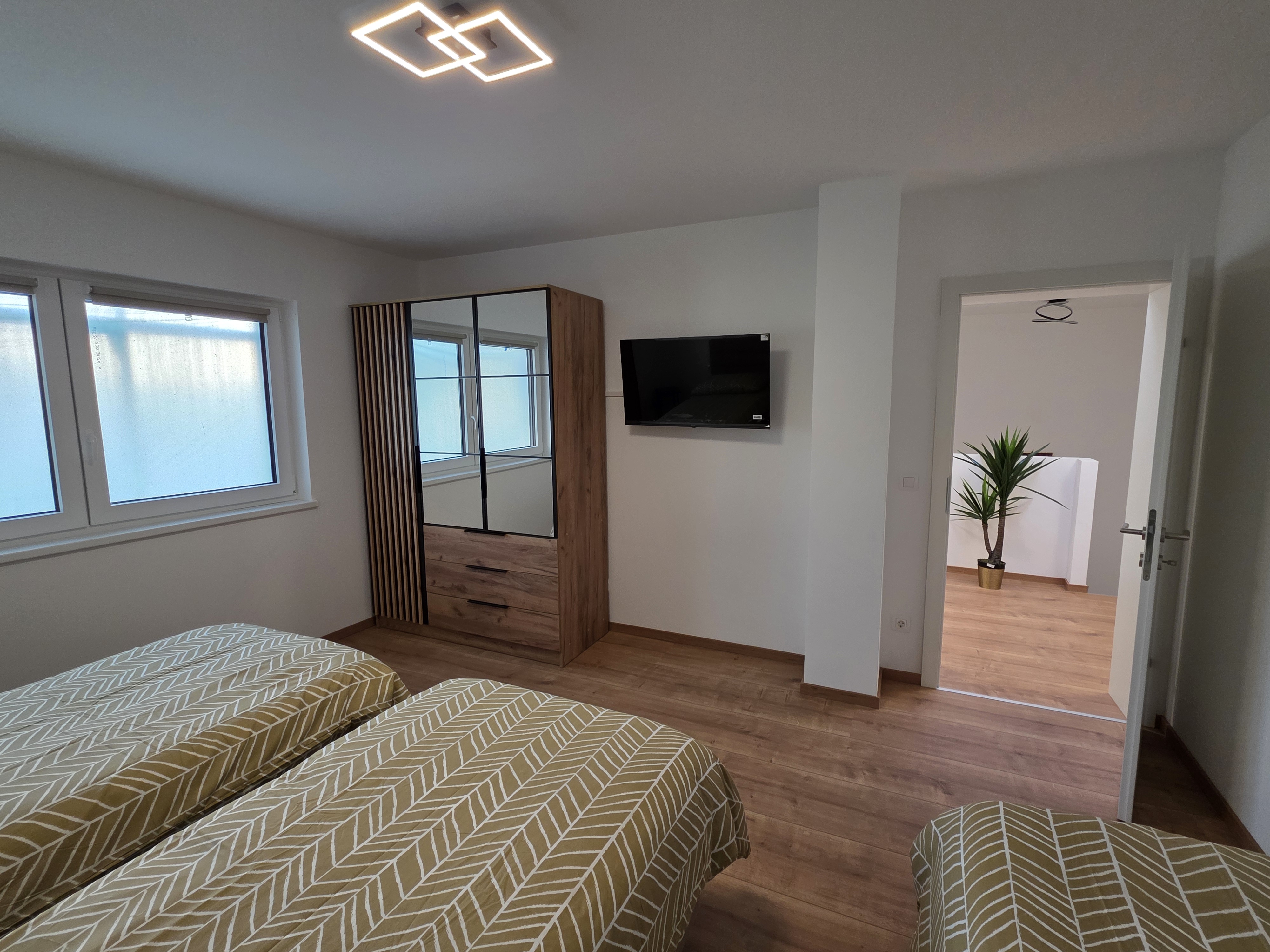 MonteurZimmer: Schlafzimmer 4 ist mit drei komfortablen Boxspringbetten, einem TV, einem Kleiderschrank sowie Steckdosen und Ablagemöglichkeiten für Handys und Wasser ausgestattet - Imperial Premium Mouteurzimmer 