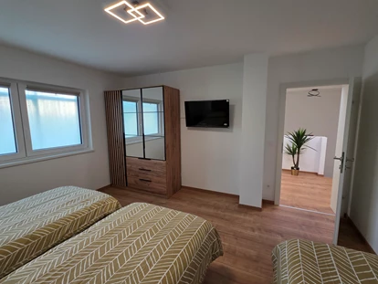 Monteur-Zimmer - Küche - Wien-Stadt - Schlafzimmer 4 ist mit drei komfortablen Boxspringbetten, einem TV, einem Kleiderschrank sowie Steckdosen und Ablagemöglichkeiten für Handys und Wasser ausgestattet - Imperial Premium Mouteurzimmer