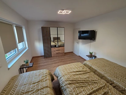 Monteur-Zimmer - Küche - Wien-Stadt - Schlafzimmer 2 ist mit drei komfortablen Boxspringbetten, einem TV, einem Kleiderschrank sowie Steckdosen und Ablagemöglichkeiten für Handys und Wasser ausgestattet - Imperial Premium Mouteurzimmer