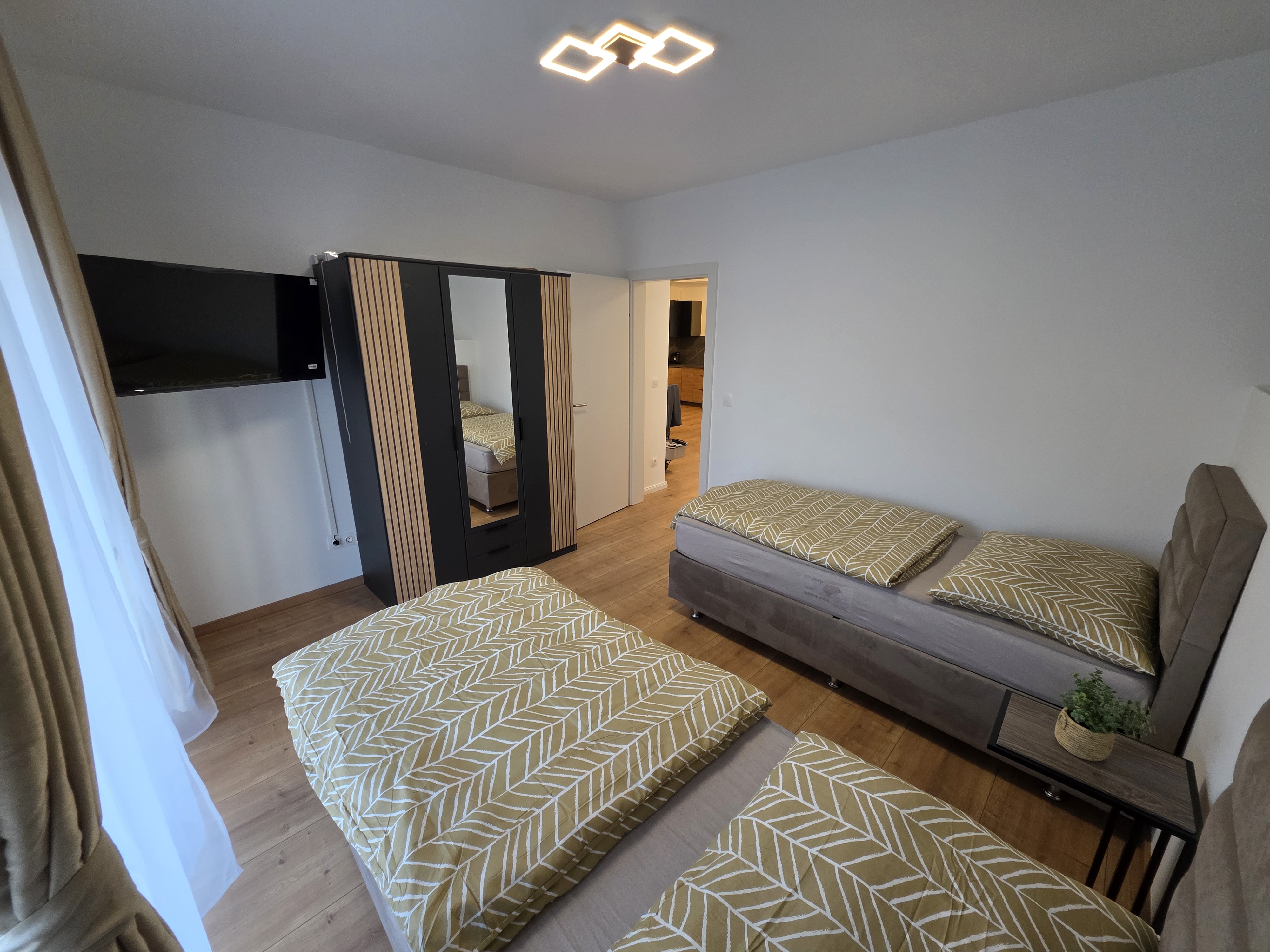 MonteurZimmer: Schlafzimmer (1) im Erdgeschoss mit zwei Einzelbetten (optional als Einzel- oder Doppelzimmer nutzbar), TV und Kleiderschrank. - Imperial Premium Mouteurzimmer 