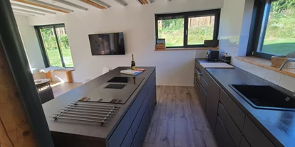 Monteur-Zimmer - Küche - Österreich - Küche mit Kochinsel und links wohnbereich mit Fernseher  - Trahütti Premium Lodges