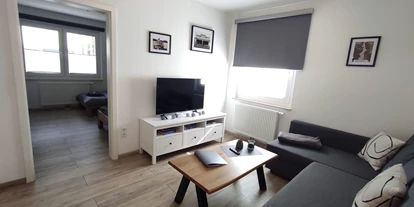 Monteur-Zimmer - Preis pro Nacht - Deutschland - Wohnzimmer mit Fernseher und Couch - Ferienwohnung "Am Rathaus" in 66849 Landstuhl