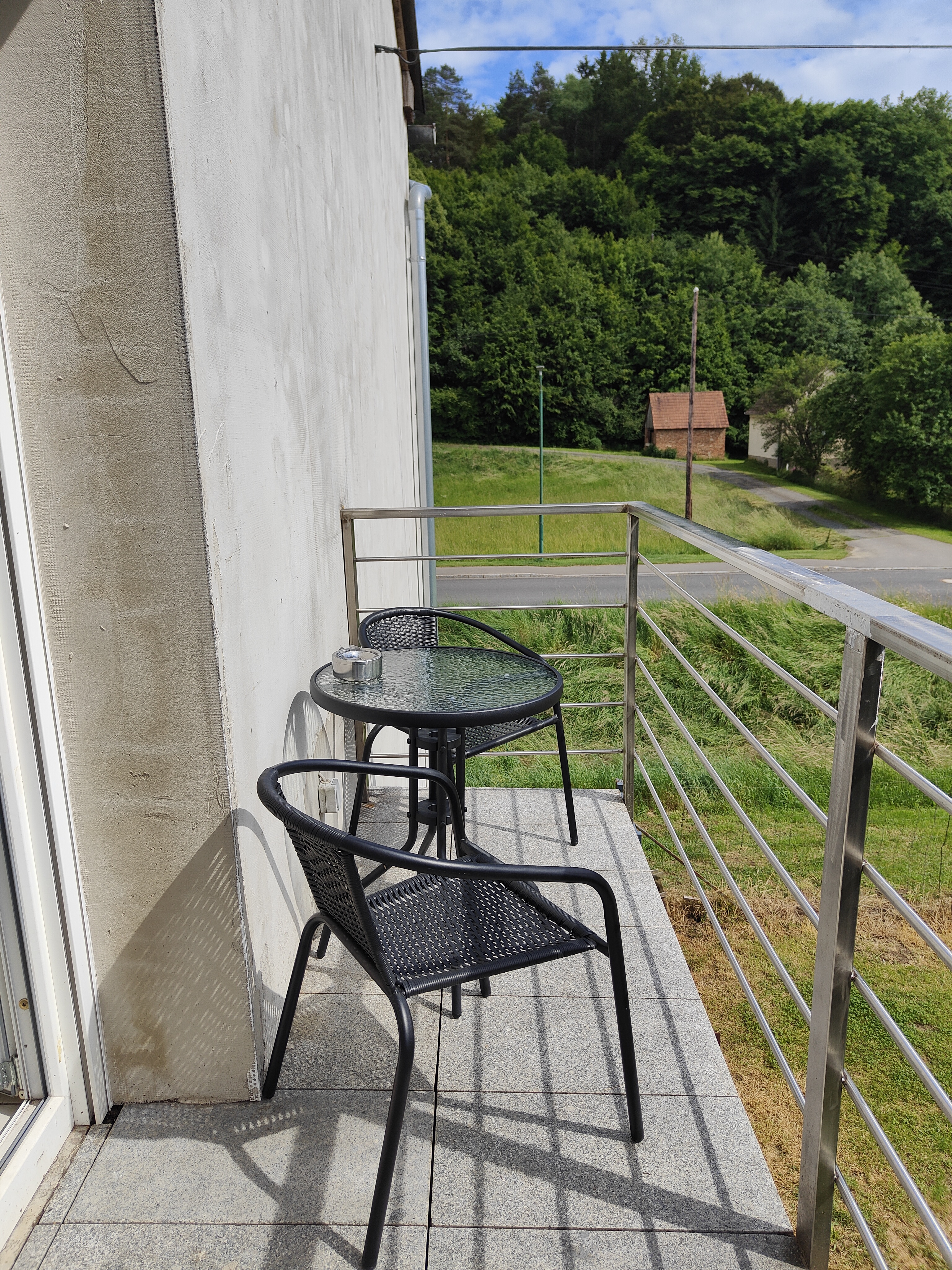 Monteur-Zimmer - Herd - Oberdrosen - Balkon mit zwei Stühlen und einem Tisch - Ferienwohnung Waldblick